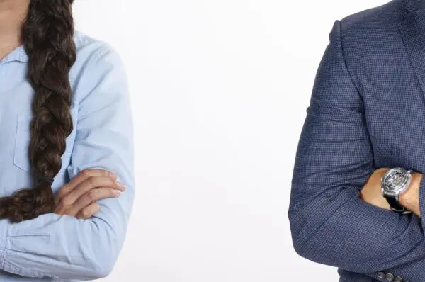 Two people wearing long sleeve suits standing side by side